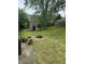 Backyard featuring a playhouse, basketball hoop, and fire pit offering opportunities for outdoor fun and relaxation at 8312 Lamira Ln, Indianapolis, IN 46234