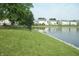 Lush green grassy bank bordering the calm waters of the pond at 847 Sylvan St, Whiteland, IN 46184