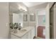 Neutral bathroom featuring a large mirror over the vanity and an open doorway into a bedroom at 9055 Glass Chimney Ln, Fishers, IN 46037