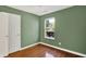Bedroom showcasing hardwood floors, a window with natural light, and a door for easy access at 9055 Glass Chimney Ln, Fishers, IN 46037