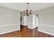 Bright dining area with hardwood floors, a chandelier, and open access to kitchen and laundry at 9055 Glass Chimney Ln, Fishers, IN 46037
