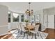 Elegant dining room featuring bay windows, hardwood floors, a wood table, and modern decor at 9055 Glass Chimney Ln, Fishers, IN 46037