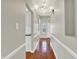 Hallway with wood flooring, white trim, and view of the front door at 9055 Glass Chimney Ln, Fishers, IN 46037