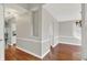 Spacious hallway with hardwood floors, neutral paint, and entryways to dining and kitchen areas at 9055 Glass Chimney Ln, Fishers, IN 46037