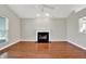 Bright living room features a fireplace, wood floors, a ceiling fan, and light gray paint at 9055 Glass Chimney Ln, Fishers, IN 46037