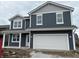 New construction two-story home featuring a large white garage door, a blue facade, and white window trim at 9125 Steinbeck Ln, Indianapolis, IN 46239