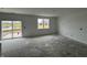 Spacious living room with a large window overlooking a pond and sliding glass door access to the backyard at 9125 Steinbeck Ln, Indianapolis, IN 46239