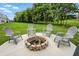 Backyard fire pit area featuring Adirondack chairs on a concrete patio and a lush green lawn at 10113 Gallop Ln, Fishers, IN 46040