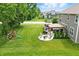 Aerial view of a spacious backyard with a playset, a pergola over an outdoor seating area, and lush green lawn at 10113 Gallop Ln, Fishers, IN 46040