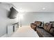 Finished basement showcasing reclining leather seating, a large wall-mounted television, and neutral walls and carpet at 10113 Gallop Ln, Fishers, IN 46040