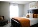 Bright bedroom featuring a dark wood bed frame, crisp white bedding, and an accenting orange quilt at 10113 Gallop Ln, Fishers, IN 46040