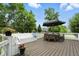Spacious outdoor deck area featuring bench seating, an umbrella shaded table, and decorative potted plants at 10113 Gallop Ln, Fishers, IN 46040