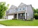 Charming two-story home with brick and gray siding, covered porch, and well-manicured lawn at 10113 Gallop Ln, Fishers, IN 46040