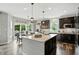 Open kitchen boasts a large island, stainless appliances, dark cabinets, and an adjacent dining area with outdoor access at 10113 Gallop Ln, Fishers, IN 46040