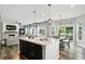 Modern kitchen featuring a large island with pendant lighting, a breakfast bar, and hardwood floors at 10113 Gallop Ln, Fishers, IN 46040
