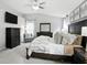 Well-lit primary bedroom boasts a king bed, a sitting area, a dark dresser, and soft neutral decor at 10113 Gallop Ln, Fishers, IN 46040