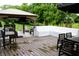 Spacious wood deck with a built-in bench, shaded by a large umbrella, next to a covered outdoor kitchen at 10113 Gallop Ln, Fishers, IN 46040