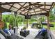 Outdoor patio under a pergola, including a BBQ grill, an outdoor fireplace, a TV and comfortable seating at 10113 Gallop Ln, Fishers, IN 46040