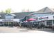 Exterior view of a shopping center with a variety of restaurants and storefronts, shaded by colorful umbrellas at 10113 Gallop Ln, Fishers, IN 46040