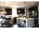 Modern kitchen with dark cabinets, a large island with seating, and stainless steel appliances at 10113 Gallop Ln, Fortville, IN 46040