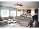 Open-concept living room with a large sectional sofa, adjacent kitchen, and ample natural light at 10113 Gallop Ln, Fortville, IN 46040