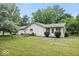 A spacious backyard with a grass lawn and a patio area with a view of the home and some trees at 110 Leichester Ct, Noblesville, IN 46060