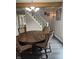 Cozy dining area with a large wooden table, wicker chairs and a view of the stairs at 121 N Main St, Pendleton, IN 46064