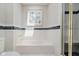 Bathroom featuring a bathtub with white tiling, a shower, and a black-tiled border at 121 Wesley Cir, Noblesville, IN 46062