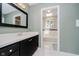 Bathroom featuring a vanity with black cabinetry, a white countertop, a mirror, and a view of the bathtub at 121 Wesley Cir, Noblesville, IN 46062