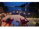 Relaxing waterfront deck with red Adirondack chairs and overhead string lights at 121 Wesley Cir, Noblesville, IN 46062