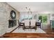 Charming dining room with stone fireplace, modern chandelier, and large windows with outdoor view at 121 Wesley Cir, Noblesville, IN 46062
