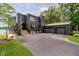Modern home featuring dark siding, an attached three-car garage, and manicured landscaping at 121 Wesley Cir, Noblesville, IN 46062