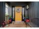 Inviting front porch featuring a cheerful yellow door, potted plants, and decorative accents at 121 Wesley Cir, Noblesville, IN 46062