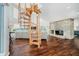 Open-concept living room with a spiral staircase, stone fireplace, and lake views at 121 Wesley Cir, Noblesville, IN 46062