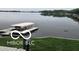 Waterfront property with covered boat lift, serene lake view, and green grass at 121 Wesley Cir, Noblesville, IN 46062