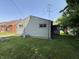 View of the back exterior with siding, windows, and a partial yard at 1227 W 9Th St, Anderson, IN 46016