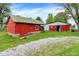 Property view of a barn with a red painted exterior complemented by a gravel driveway on a grassy lot at 12471 N 100 E, Alexandria, IN 46001