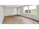 Well-lit bedroom with gleaming wood floors, neutral walls, and two large windows offering scenic outdoor views at 12471 N 100 E, Alexandria, IN 46001