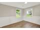 Bedroom featuring wood-look flooring, wainscoting and two windows with outside views at 12471 N 100 E, Alexandria, IN 46001
