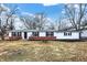 Charming single-story home with brick accents, green roof, and manicured front yard on a sunny day at 12471 N 100 E, Alexandria, IN 46001