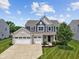Charming two-story home with a three car garage, landscaped front yard and blue siding at 1306 Avocet Dr, Greenwood, IN 46143