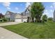 Lovely front lawn and landscaping of a blue and brick two story home with 3 car garage at 1306 Avocet Dr, Greenwood, IN 46143