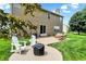 Scenic backyard with patio area, lounge chairs, a fire pit, and lush lawn, great for outdoor gatherings at 13191 Roma, Carmel, IN 46074