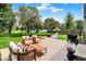 Backyard patio with outdoor seating, grill, and fire pit, overlooking a manicured lawn and pond for relaxing at 13191 Roma, Carmel, IN 46074
