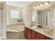 Bright bathroom featuring a soaking tub, double sinks, and updated fixtures, offering a luxurious feel at 13191 Roma, Carmel, IN 46074