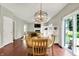Bright dining room with wood floors, modern chandelier, and sliding glass doors at 13191 Roma, Carmel, IN 46074