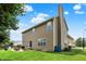 View of the tan home featuring a patio with outdoor furniture and a spacious backyard lawn at 13191 Roma, Carmel, IN 46074