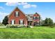 Charming brick two-story home featuring a lush green lawn and beautiful hydrangeas at 13191 Roma, Carmel, IN 46074
