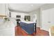 A spacious kitchen featuring stainless steel appliances, white cabinets, an island with barstools, and hardwood floors at 13191 Roma, Carmel, IN 46074