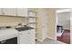 Well-lit laundry room with a white washer and dryer, overhead storage, and wire shelving at 13191 Roma, Carmel, IN 46074